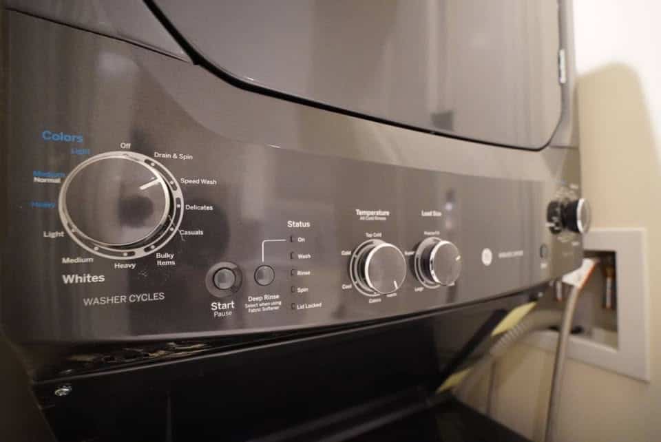 Washer machine control panel with various cycle options and settings, SEO optimized for Orca Realty Inc. property listings in Vancouver.