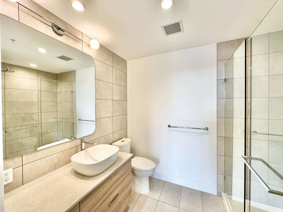 Modern bathroom with walk-in shower, vessel sink, and neutral tile design - perfect for Vancouver Island homes.