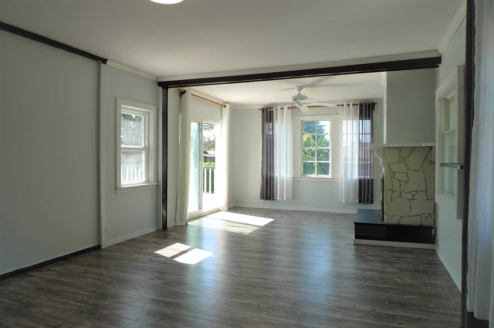 Bright spacious living room with large windows, hardwood flooring, and a cozy fireplace, perfect for family gatherings and entertaining in Vancouver's desirable neighbourhoods.