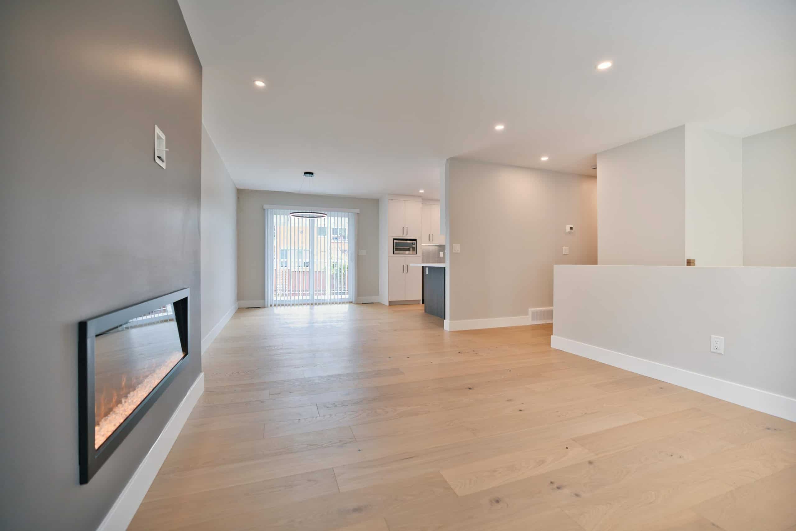 Bright, open-concept living space with modern finishes, hardwood floors, and a sleek fireplace, ideal for Toronto real estate buyers seeking contemporary homes.