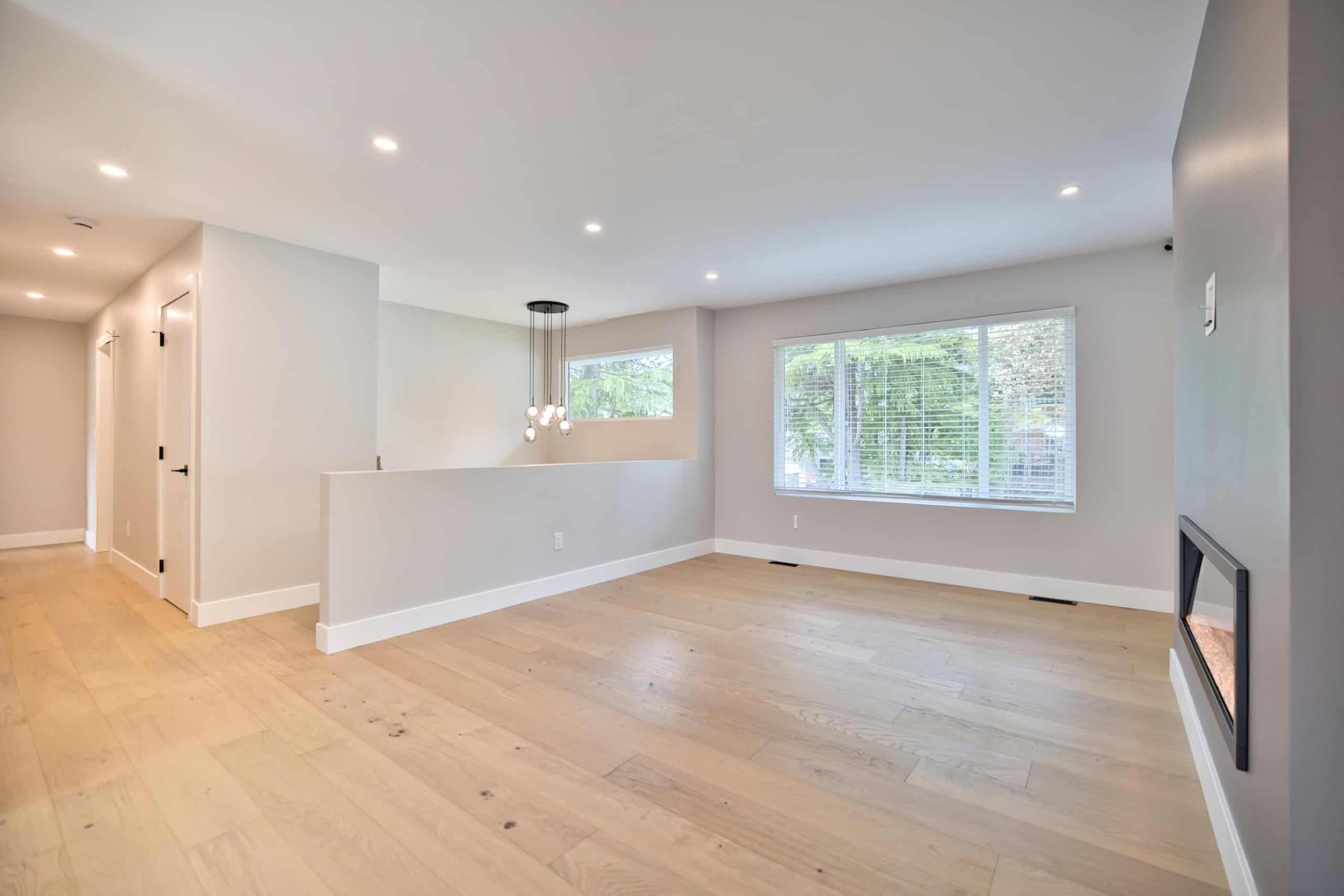 Bright spacious living room with large windows, modern design, and hardwood floors, ideal for Vancouver real estate listings and highlighting Orca Realty Inc. services.