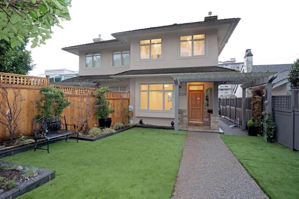 Charming modern home with well-maintained front yard, lush green lawn, and inviting entryway, perfect for Vancouver Island real estate listings.