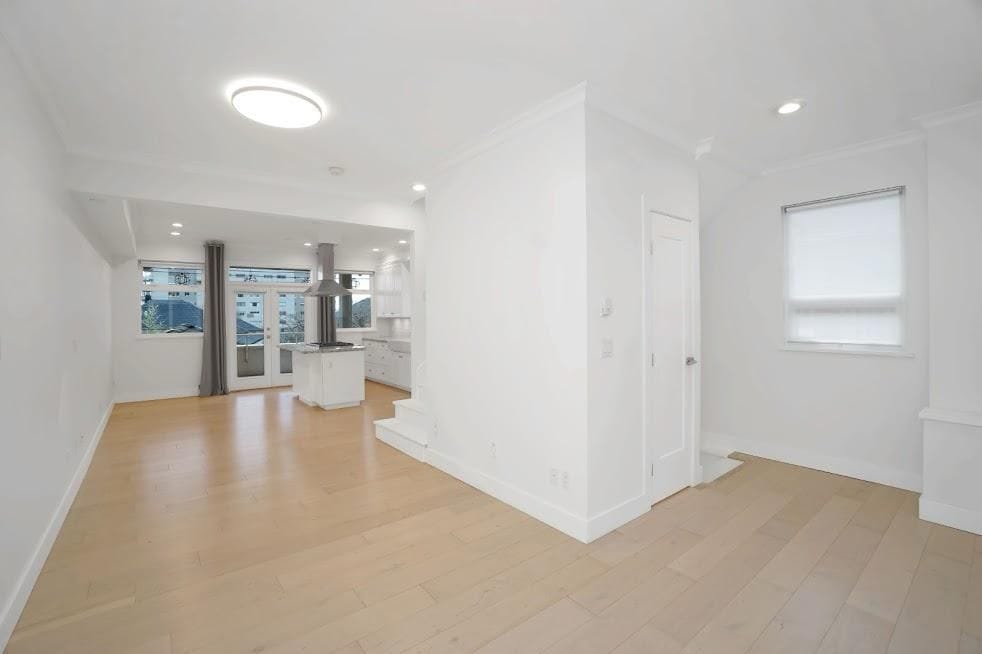 Bright open-concept living space with modern kitchen, large windows, and natural light, ideal for Vancouver real estate buyers seeking contemporary homes.