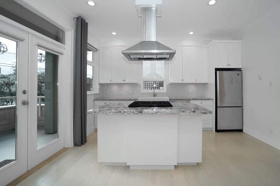 Modern white kitchen with granite countertops and stainless steel appliances in a new home. Bright, spacious, and perfect for family cooking and entertaining.