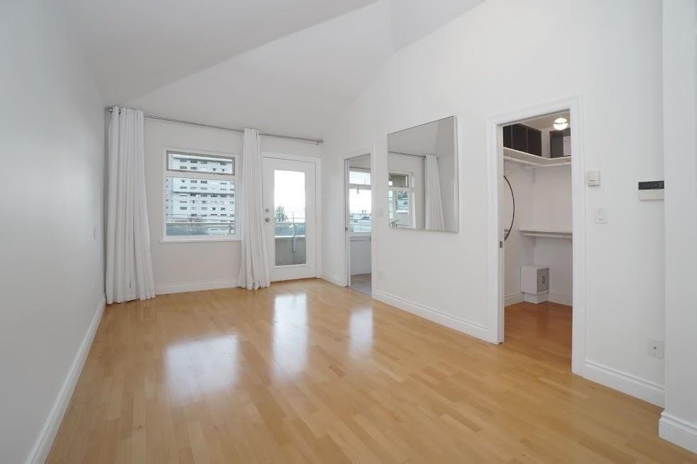 Bright living room with hardwood floors, large windows, and balcony access; ideal for Vancouver condo buyers seeking modern, airy spaces.