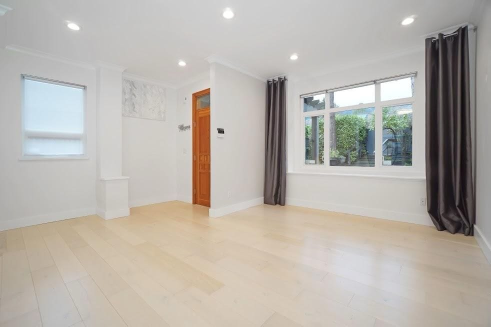 Bright and spacious living room with large windows, natural light, and modern white walls, perfect for homebuyers in Vancouver.