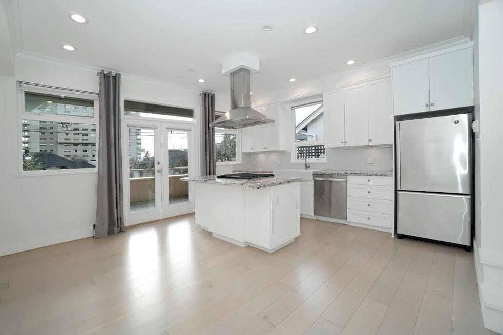 Spacious modern kitchen with white cabinets, stainless steel appliances, and granite countertops, perfect for Vancouver real estate buyers.