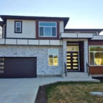 Modern contemporary house exterior with stone accents, large windows, and a stylish front entrance, located in a desirable Vancouver neighbourhood.