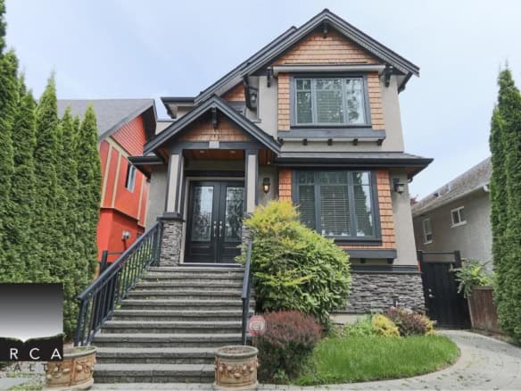 Beautiful modern house with landscaped front yard, stone steps, and black accents, showcasing Orca Realty Inc. expertise in Vancouver real estate and home buying services in BC.