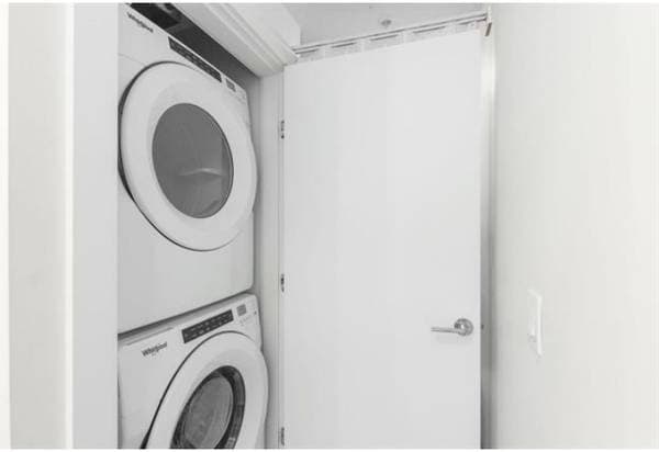 Washer and dryer stacked in a small laundry closet in a residential property, showcasing efficient use of space.