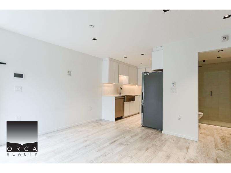 Modern open-concept kitchen and living space in Vancouver condo for sale by Orca Realty Inc.