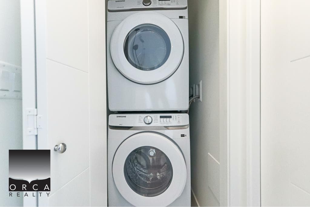 Stacked washer and dryer in a modern laundry closet, ideal for small or apartment living, showcasing efficient laundry appliances, part of Vancouver property listings.
