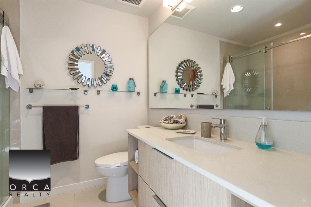 Modern bathroom with contemporary decor, stylish mirror, and sleek fixtures showcasing high-end residential design by Orca Realty Inc.