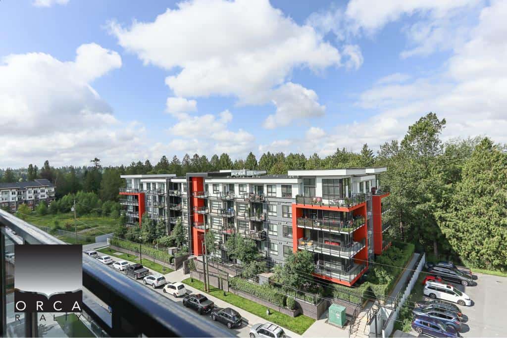 Modern multi-family residential building with spacious balconies surrounded by greenery in Vancouver, BC.