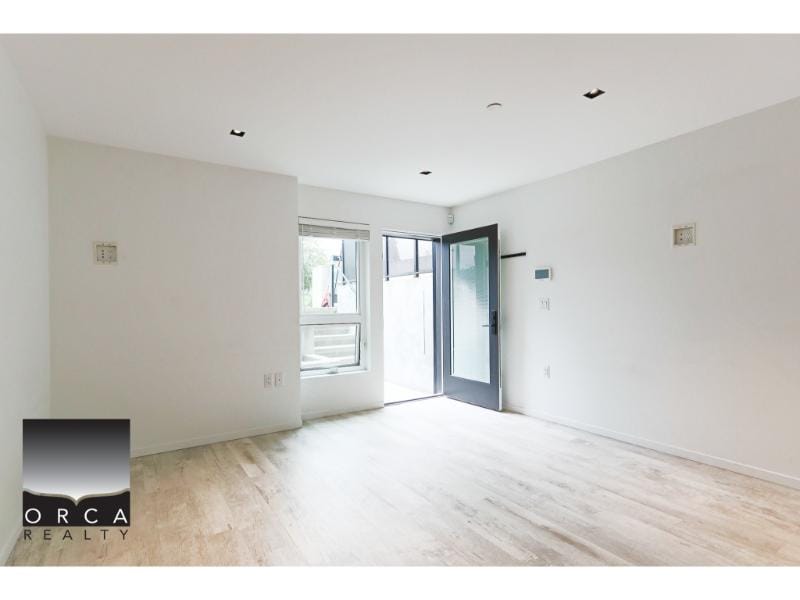 Bright empty living room with large window and open front door, new modern home interior, natural light, minimalistic design, ideal for real estate in Vancouver or BC.