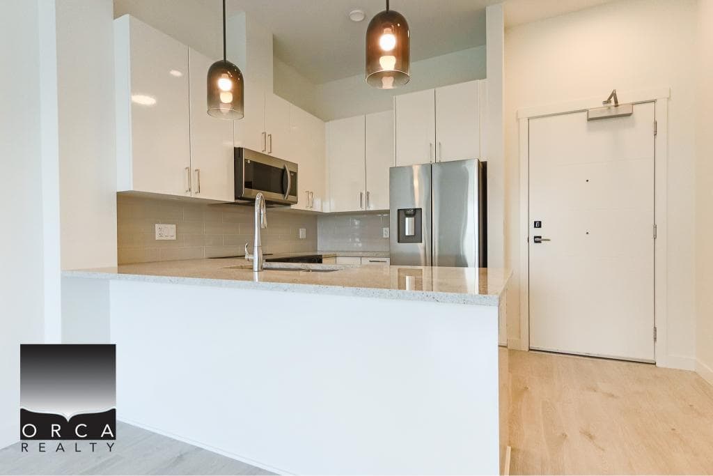 Stunning modern kitchen with white cabinets, stainless steel appliances, and quartz countertops, perfect for Vancouver Island living.