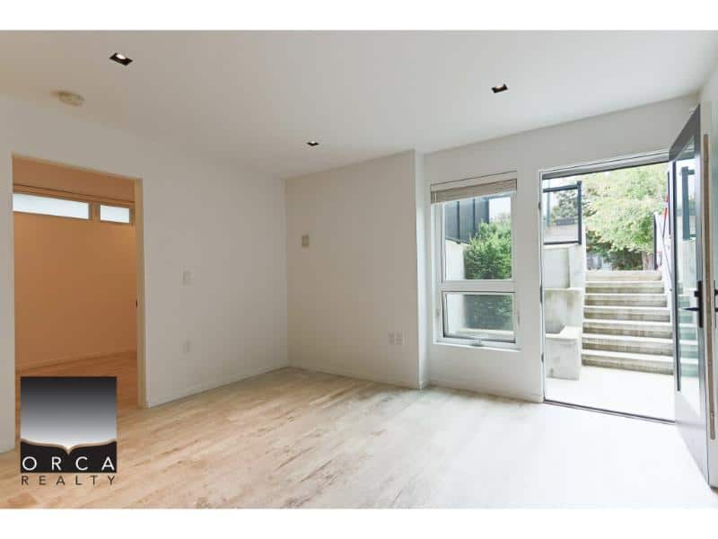 Bright open living space with large windows and outdoor access, perfect for Vancouver real estate buyers looking for modern homes by Orca Realty Inc.