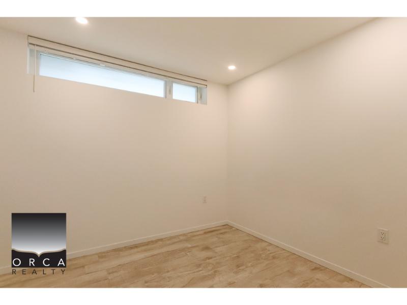 Bright empty room with high windows and modern finishes, ideal for home staging or renovation projects - perfect real estate opportunity near Orca Realty.