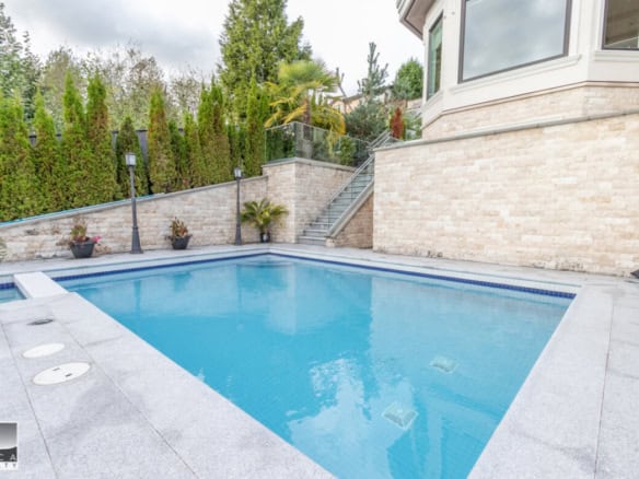 Elegant backyard pool with modern design and surrounding lush greenery in a luxury Vancouver home. Ideal for relaxing and entertaining in a private setting.