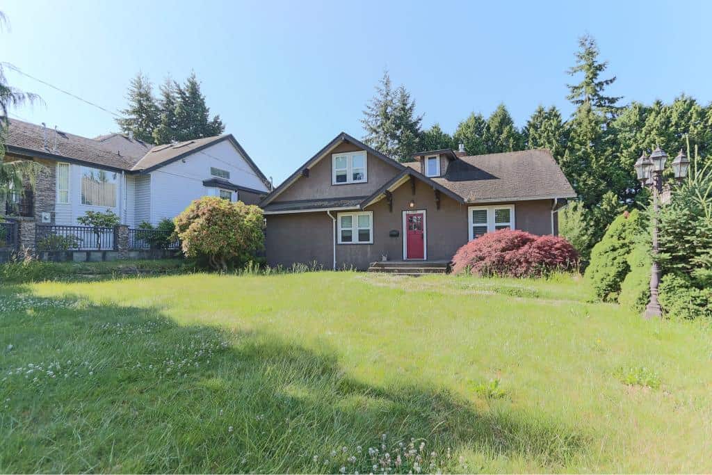 Charming 2-storey house with lush green backyard, landscaped garden, and mature trees, offering ideal conditions for homeowners seeking real estate options in Victoria BC.