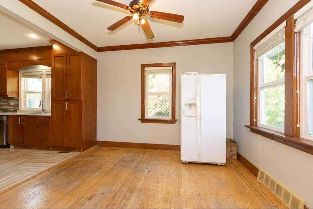 Bright kitchen and dining area with large windows, hardwood floors, and modern cabinetry at Orca Realty Inc. in Victoria, BC.