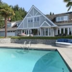 Luxury home with swimming pool and outdoor seating, featuring modern architecture and lush greenery, perfect for real estate listings in British Columbia.