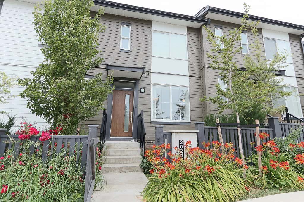 Modern townhouse with landscaped garden and urban exterior, available through Orca Realty Inc., emphasizing prime Vancouver real estate and property management services in British Columbia.