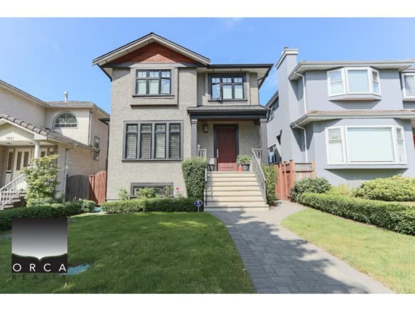 Modern Vancouver-style duplex home with landscaped front yard and stairs leading to the main entrance, showcasing quality property listings by Orca Realty Inc. in BC.