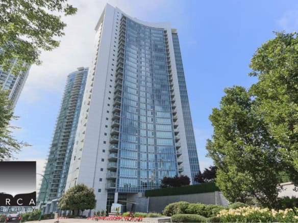 Modern high-rise residential building in Vancouver with glass exterior, surrounded by lush greenery, representing premier condo real estate, downtown location, and luxury living in Vancouver, BC.