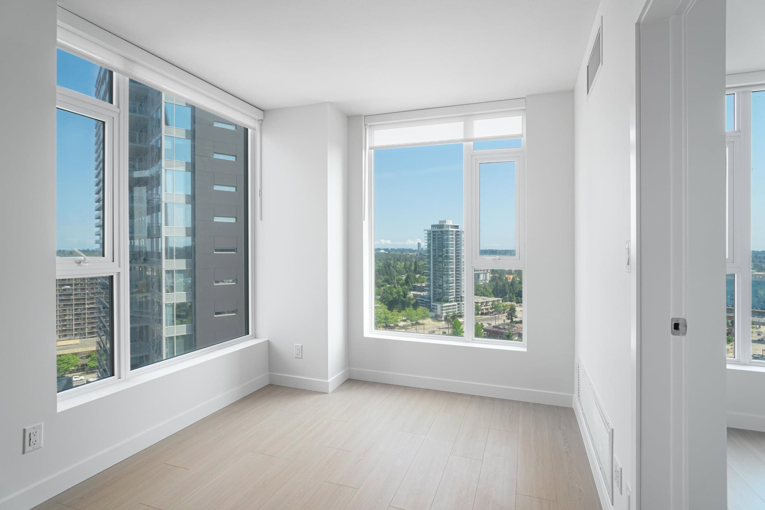 Bright modern condo interior with large windows and city skyline views, ideal for Vancouver real estate buyers looking for luxury apartments or investment properties.