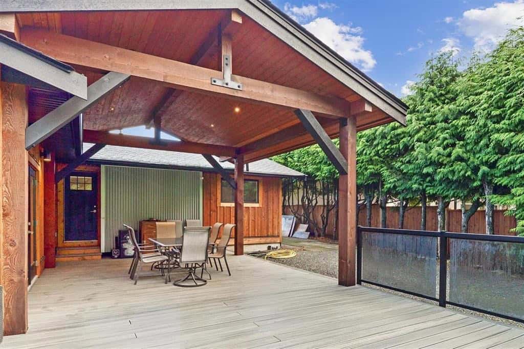 Spacious outdoor deck with seating area and wooden pergola, ideal for relaxing or entertaining in a Vancouver Island home.
