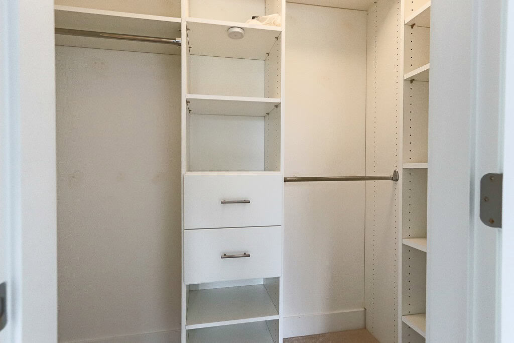 Large walk-in closet with built-in shelves and hanging rods, ideal for organizing various clothing and accessories. Perfect for homes listed by Orca Realty Inc. in BC.