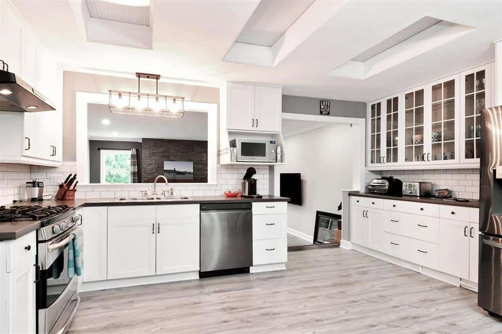 Bright modern kitchen with white cabinetry, stainless steel appliances, and a spacious layout, perfect for Vancouver real estate buyers seeking stylish homes.