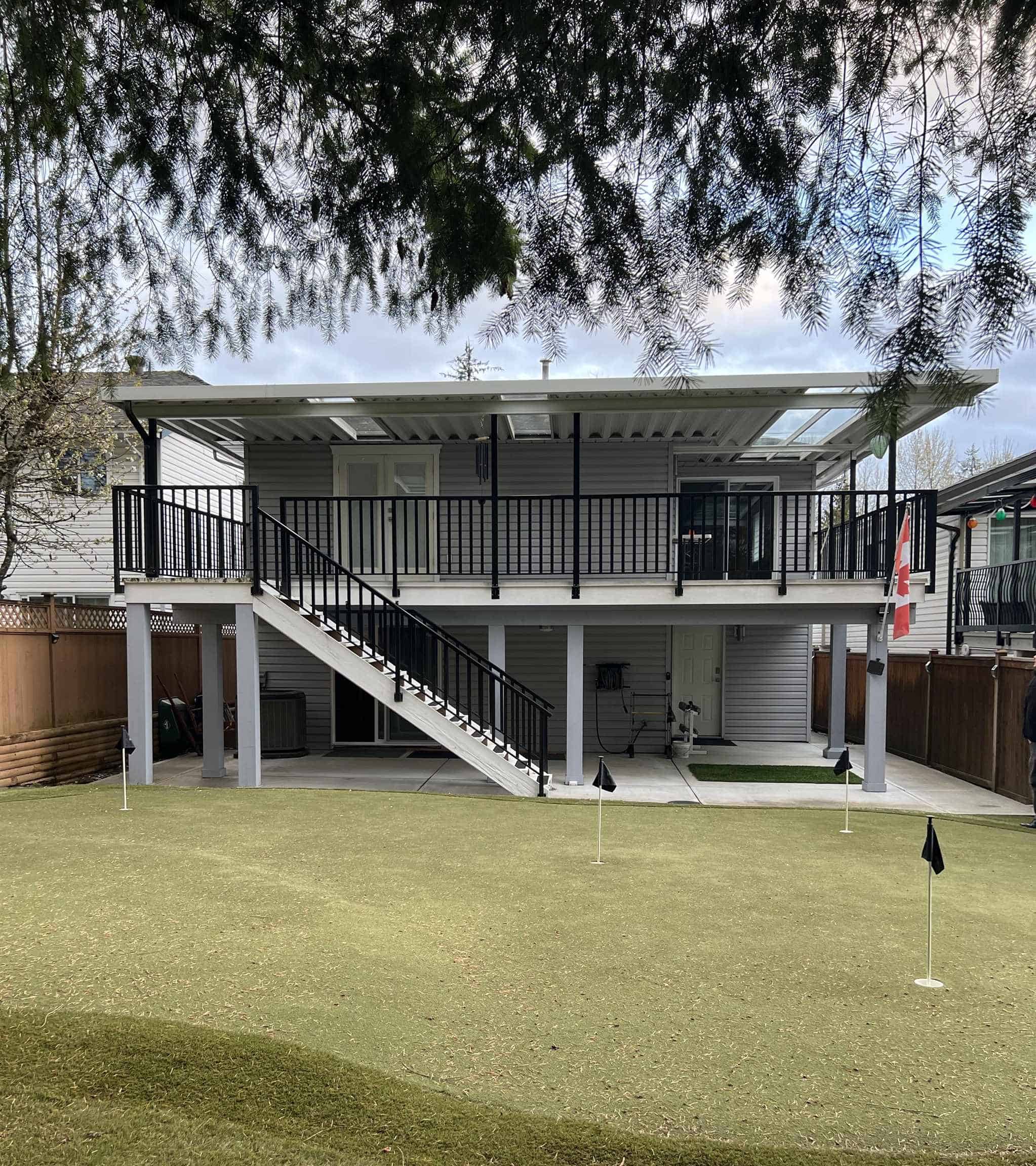 Spacious backyard view of a modern two-story home with a large deck and a manicured lawn, perfect for family gatherings and outdoor entertainment.