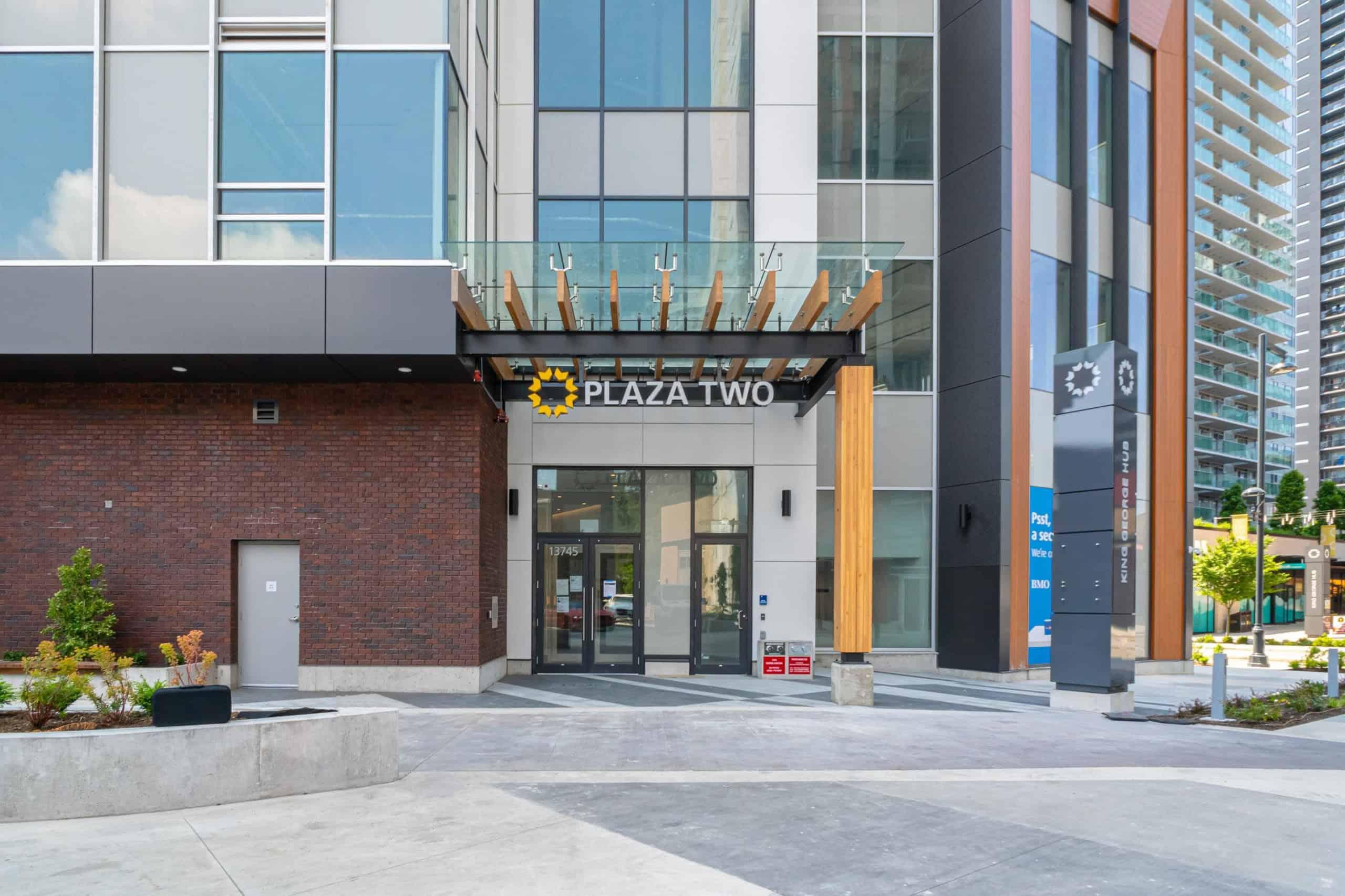 Modern urban commercial building entrance with "Plaza Two" signage, contemporary architectural design, and glass elements, located in downtown Vancouver, ideal for Vancouver real estate and commercial leasing.