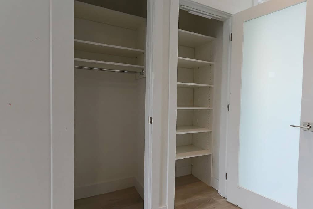 Spacious closet with built-in shelves and hanging rod, ideal for organized storage in a modern home.