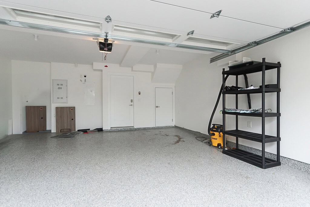 Clean spacious garage interior with storage shelving, garage door opener, and utility area, perfect for Vancouver real estate and home development projects.