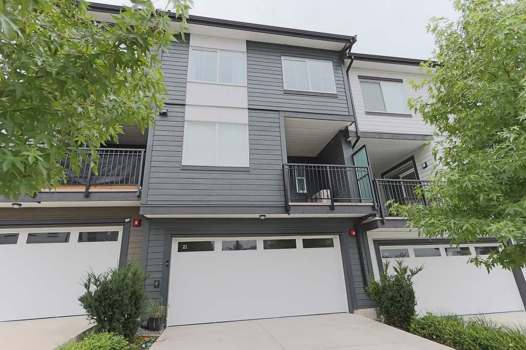 Contemporary multi-family townhouse with modern design, grey siding, spacious balconies, and attached garages, situated in a desirable neighbourhood - perfect for real estate investment or homeownership in BC.