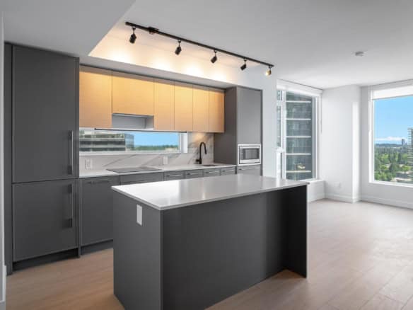 Modern grey and wood kitchen interior with large windows, panoramic city views, minimalist cabinetry, and contemporary appliances – ideal for Vancouver condo living.