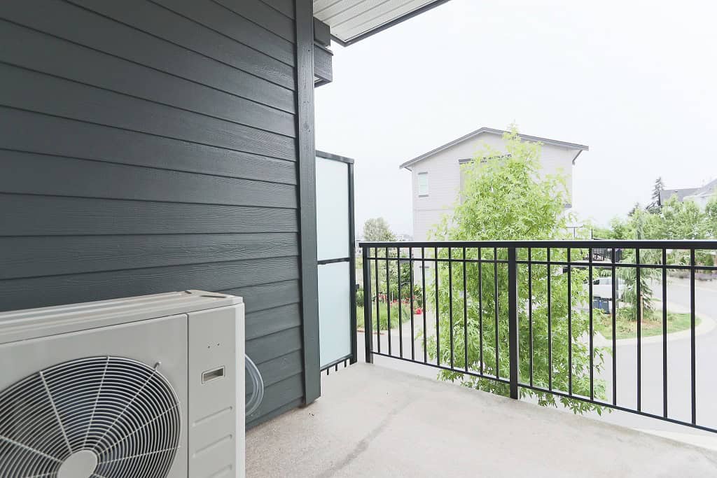 Modern balcony with black metal railing and view of suburban neighborhood, perfect for condo living in Victoria.