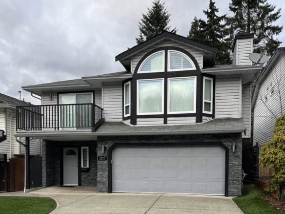 Contemporary modern family home with large bay window, front garage, balcony, grey siding, and landscaped green lawn, available through Orca Realty Inc. in BC, ideal for homebuyers and real estate investors.