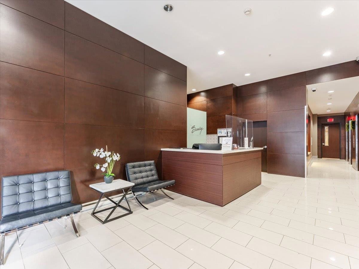 Homer 4 Modern real estate office reception area with wooden paneling, sleek waiting chairs, and a in-person client check-in desk at Orca Realty Inc. Vancouver-based property experts.