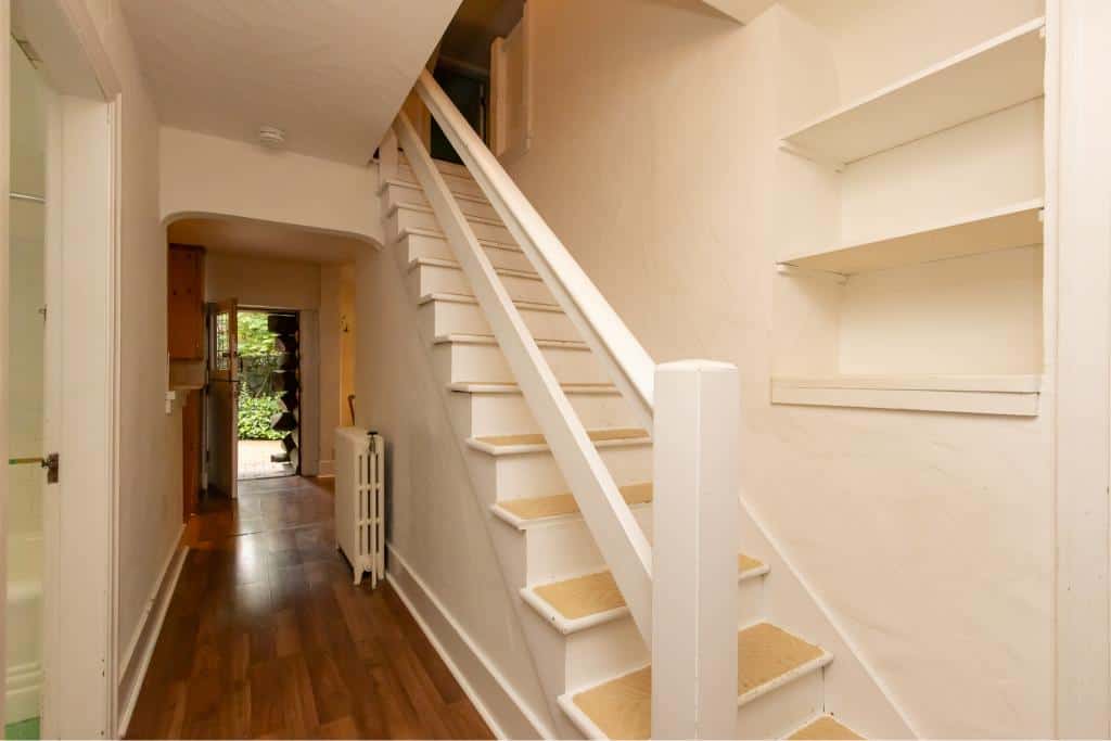 Bright indoor staircase with white railings and wooden floors, leading to upper level in a cozy home. Perfect for BC real estate listings.