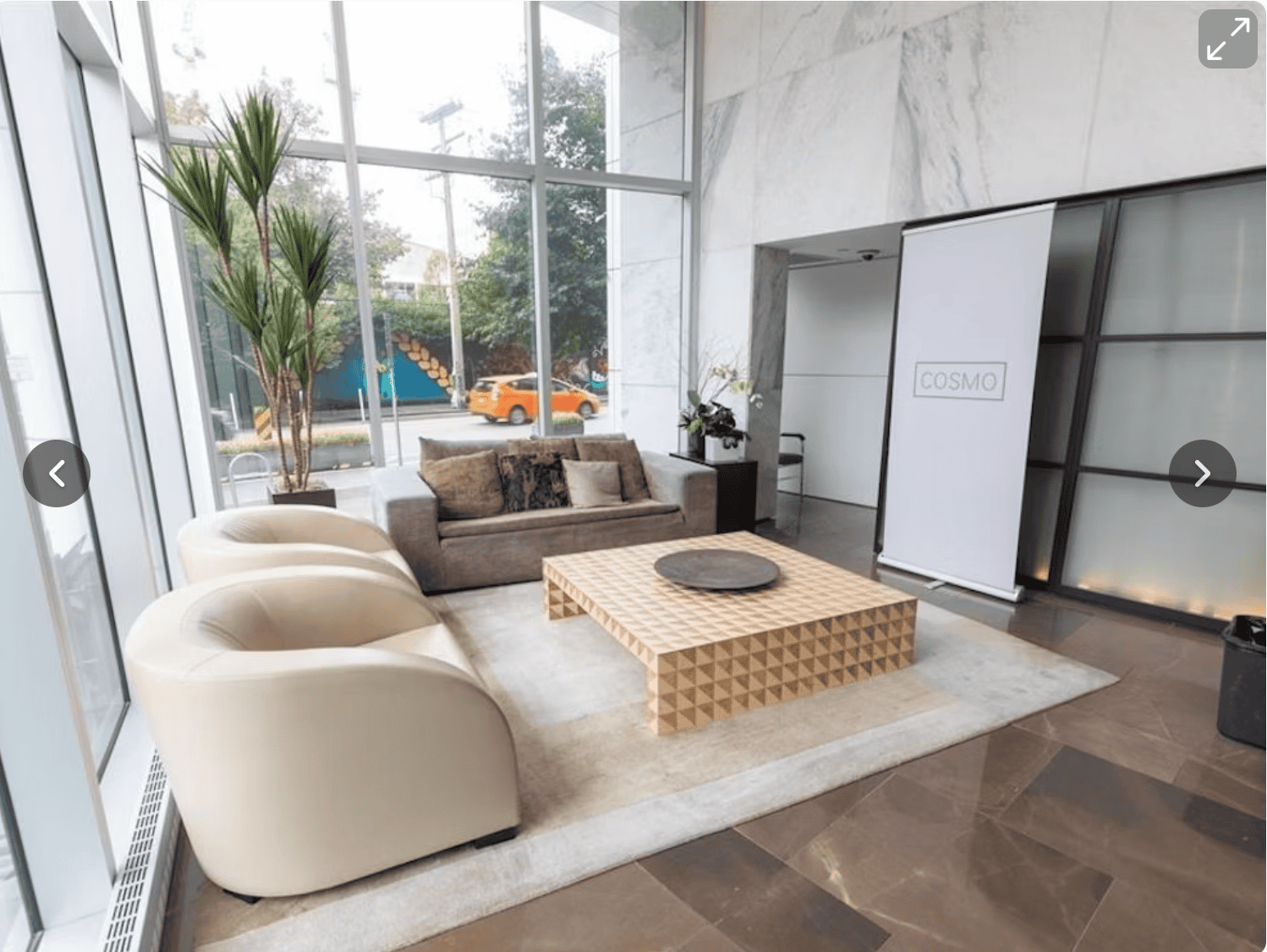 Modern commercial lobby with large glass windows and contemporary furniture, showcasing professional and welcoming environment for clients at Orca Realty Inc.