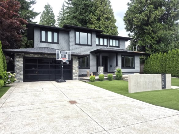 Modern Vancouver-style home with contemporary design, spacious driveway, and lush landscaping in British Columbia. Perfect for luxury real estate and property listings.