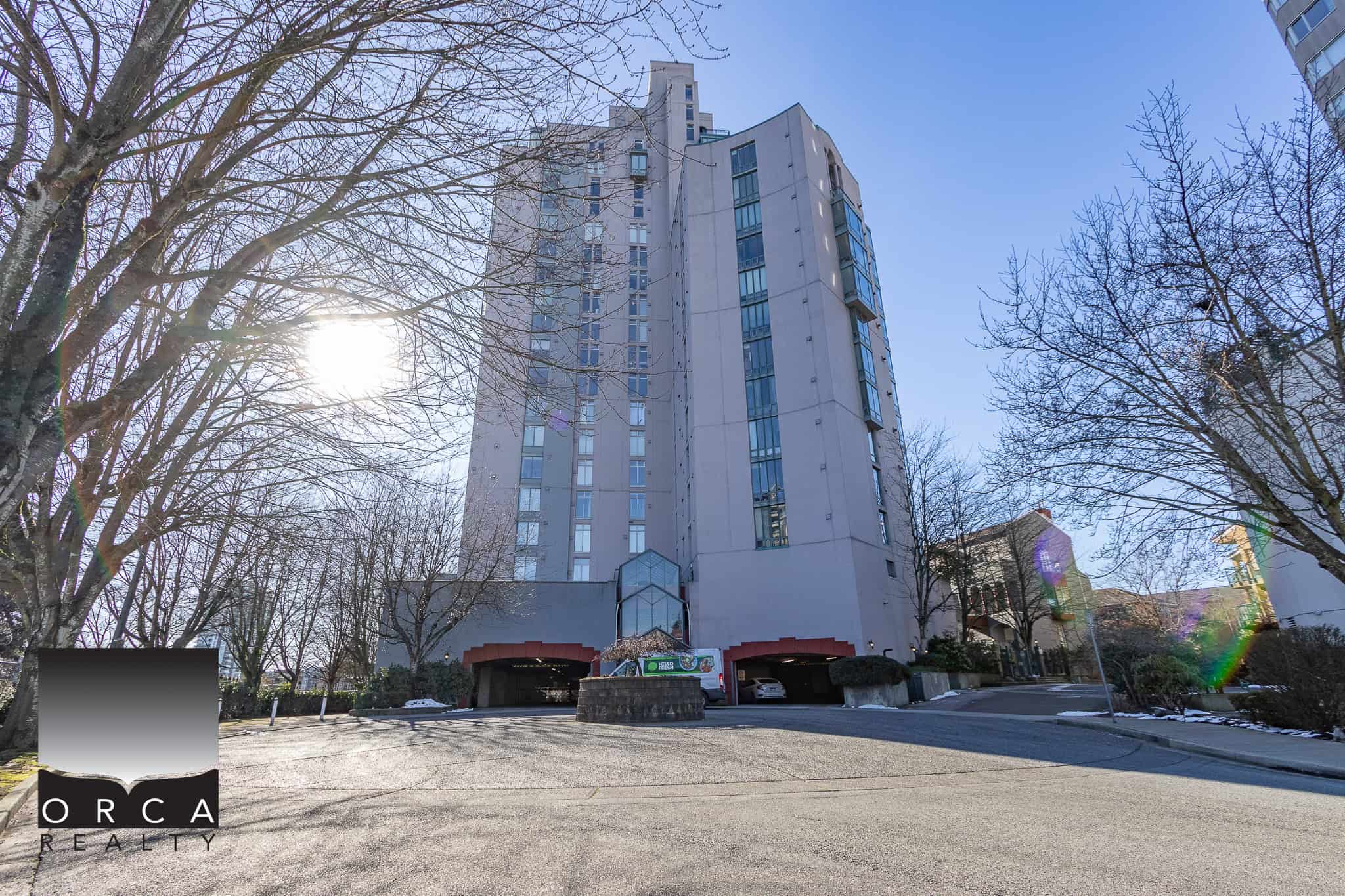 Modern high-rise condominium building with parking garage, located in Vancouver, BC, offering prime real estate opportunities. Suitable for residential or investment purposes.