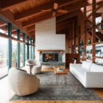 Modern living room with large floor-to-ceiling windows, cozy furniture, and a fireplace, showcasing a stylish, open-concept design ideal for Vancouver real estate.