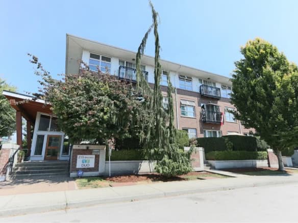 Modern multi-family apartment building with landscaped surroundings and trees, located at 215 Douglas Avenue, Vancouver, with improved features for comfortable urban living.