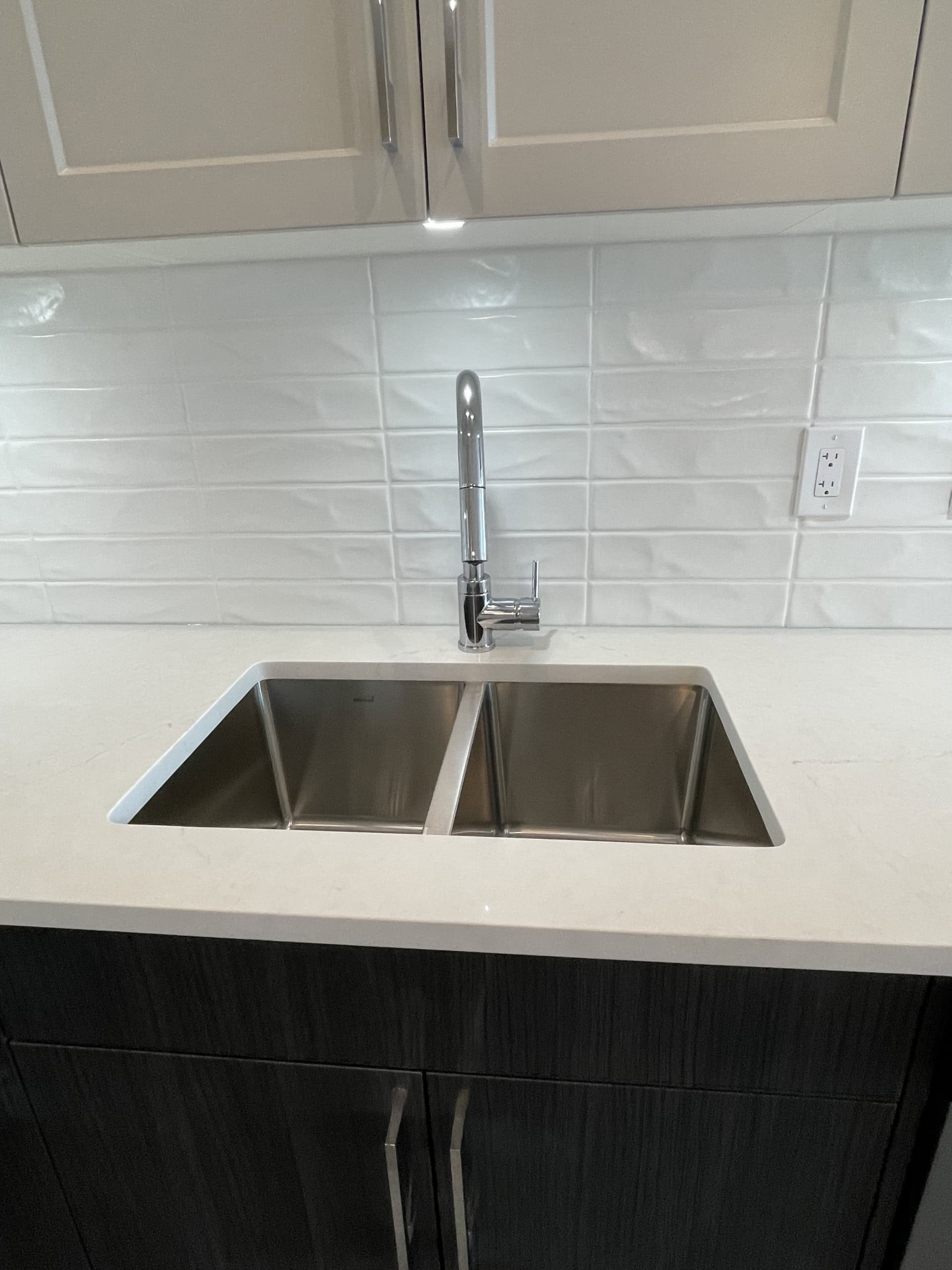 kitchen sink Modern stainless steel kitchen sink with chrome faucet in a contemporary kitchen setting.