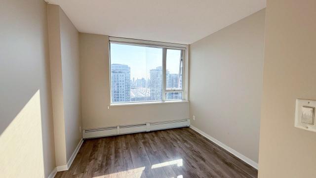 Bright downtown Vancouver apartment with large window and city views, ideal for Vancouver real estate investment or new home buyers seeking modern condos.